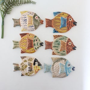 Puede incluir: Seis adornos de pescado de cerámica en varios colores y patrones. Los peces son de diferentes tamaños y formas, y tienen una variedad de detalles, como escamas, aletas y ojos. Son una gran adición a cualquier decoración del hogar.