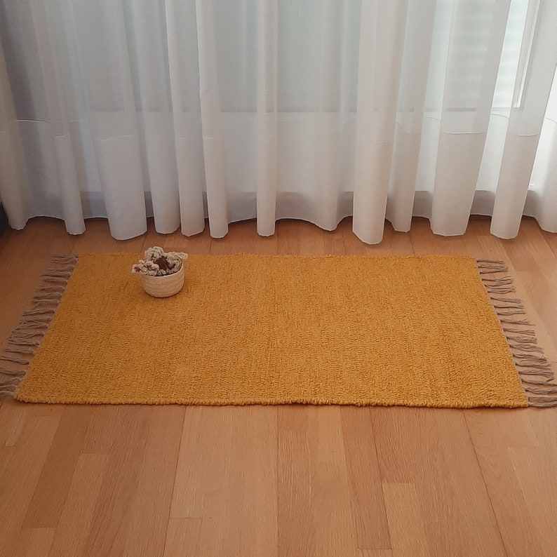 small mustard yellow rug, measuring 60x110cm (2.0x3.6 feet), with fringes and soft touch