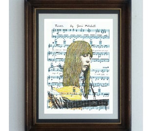 May include: A framed print featuring a stylized illustration of a person with long hair playing a guitar, overlaid on sheet music titled River by Joni Mitchell. The artwork uses yellow, black, and white tones, enclosed in a dark brown wooden frame.