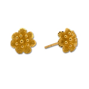 May include: A pair of gold flower-shaped stud earrings with a textured surface.