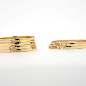 May include: Four gold rings with the names "Daniel", "Lily", "Talia", and "Daniel" engraved on them. Two gold rings with Roman numerals "VIII.XI.M.MMXIV" and a heart symbol engraved on them.