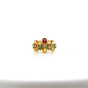 May include: A gold ring with a cluster of green, yellow, and red gemstones set in a flower shape.