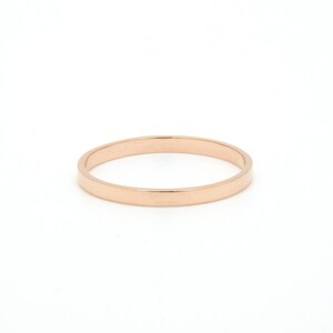 May include: A simple, plain rose gold band ring.
