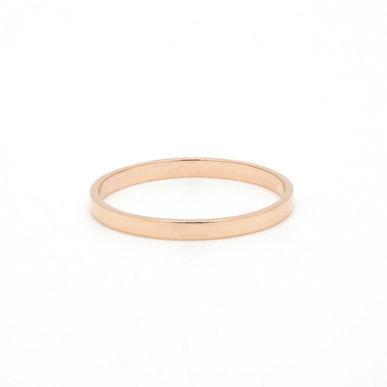May include: A simple, plain rose gold band ring.