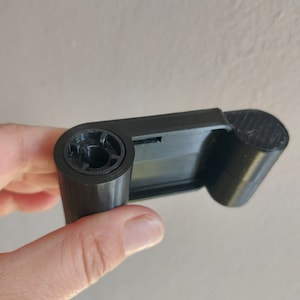 May include: A black 3D printed object with a round opening and a flat surface