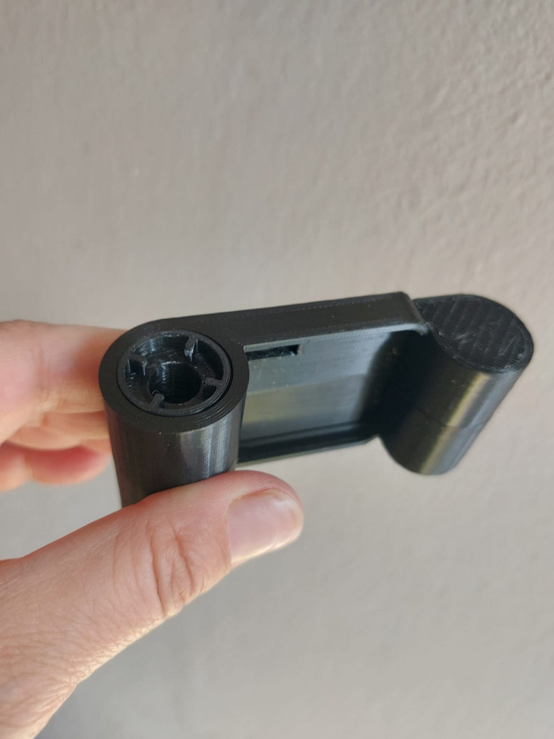 May include: A black 3D printed object with a round opening and a flat surface
