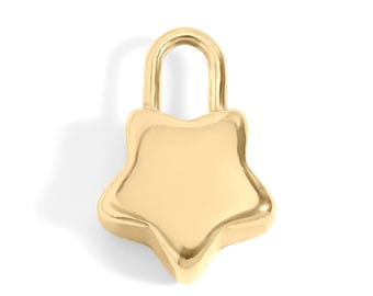 Puede incluir: Un dije dorado en forma de estrella con un lazo superior redondeado. El dije tiene una superficie lisa y pulida y un diseño de estrella de cinco puntas. El dije probablemente está hecho de metal y está sobre un fondo blanco.