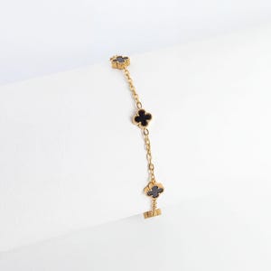 Gold Small Floral Motif Bracelet  with black heart charms on a white background