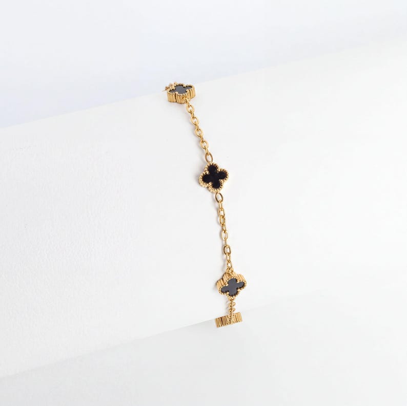 Gold Small Floral Motif Bracelet  with black heart charms on a white background