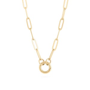 May include: A gold-toned necklace featuring elongated oval paperclip links connected to a central circular spring ring clasp. The chain consists of uniform, smooth metal links that create a continuous, structured design with a polished finish.
