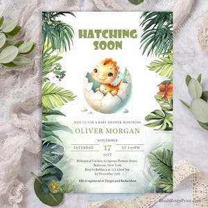 Puede incluir: Una invitación a una fiesta de bienvenida al bebé con un tema tropical verde y blanco. La invitación presenta un dinosaurio de dibujos animados saliendo de un huevo. El texto de la invitación dice "Hatching Soon" y "Oliver Morgan".
