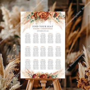 May include: A wedding seating chart on an easel, featuring the text "FIND YOUR SEAT EVELINE + CHRISTOPHER SEPTEMBER 28TH, 2029." The chart is decorated with floral and pampas grass accents in shades of orange, brown, and cream.