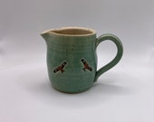 A hand thrown stoneware milk jug decorated with red kite birds.  A unique and charming gift!