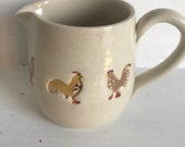 A hand made milk jug decorated with hens and cockerells. A charming and unique gift.