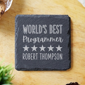 May include: Black slate coaster featuring the text "World's Best Programmer" and five stars. The name "Robert Thompson" is engraved below the stars.