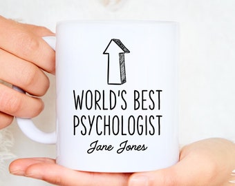 May include: White ceramic mug with black text that reads "World's Best Psychologist Jane Jones". An upward pointing arrow is above the text.