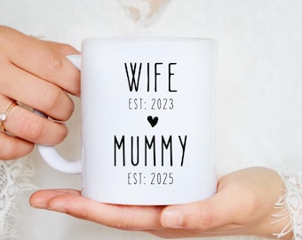 Puede incluir: Taza de cerámica blanca con texto negro que dice "Wife Est: 2023" con un pequeño corazón y "Mummy Est: 2025".