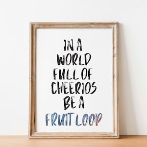 Puede incluir: Una impresión enmarcada con fondo blanco y texto negro que dice "En un mundo lleno de Cheerios, sé un Fruit Loop".