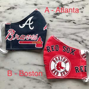 May include: Two fabric face masks, one blue with the text "A Braves" and a tomahawk, the other red with the text "Red Sox" and a white circle with the text "Boston Red Sox".