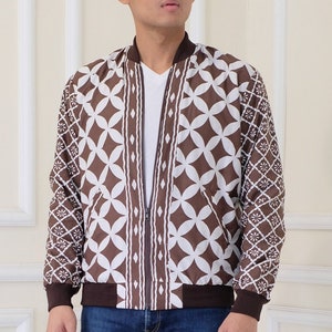 Peut inclure: Une veste bomber à motif marron et blanc avec une fermeture éclair. La veste est portée sur un t-shirt blanc à col en V.
