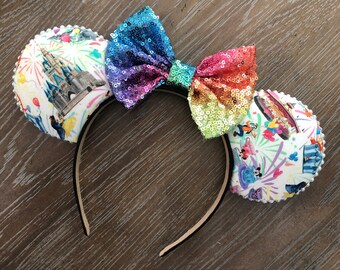 May include: A pair of white mouse ears with a rainbow sequin bow. The ears are decorated with a white background with colorful images of Disney characters and fireworks.