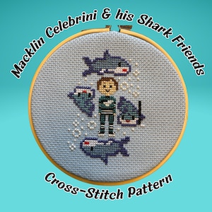 May include: Cross-stitch pattern featuring a cartoon of a person and sharks. The design is in a round wooden hoop with the text "Macklin Celebrini & his Shark Friends" and "Cross-Stitch Pattern". The background is light blue.