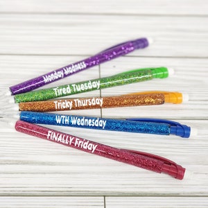 May include: Set of six glitter pencils with different colored glitter and white text on each pencil. The text reads: "Monday Madness", "Tired Tuesday", "Tricky Thursday", "WTH Wednesday", "FINALLY Friday".