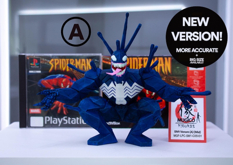 May include: A dark blue Venom figurine with white accents and a pink tongue, posed in front of a Spider-Man PlayStation game case. The figure has a jagged design and the text "NEW VERSION!" is visible.