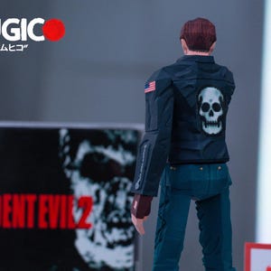 May include: A black and white action figure of a man wearing a black leather jacket with a white skull on the back. The figure is standing in front of a video game case for Resident Evil 2.