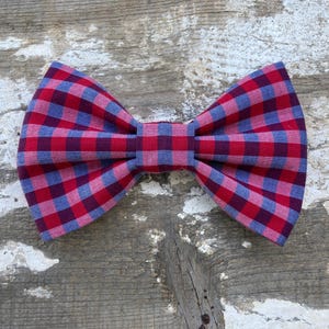 Könnte beinhalten: Eine rote und blaue karierte Fliege. Die Fliege ist aus weichem Baumwollstoff gefertigt und hat eine klassische Fliegenform.