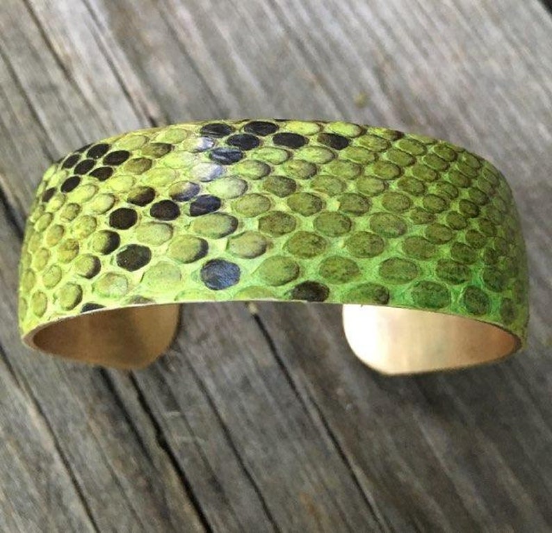 Pu&ograve; includere: Un braccialetto in pelle di serpente verde con una fascia in ottone. Il braccialetto &egrave; realizzato in vera pelle di serpente e presenta un motivo unico.