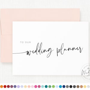 May include: A white card with black text that says "To Our Wedding Planner". The card is on a pink envelope. The card has a small logo in the bottom right corner that says "The Wedding Collection" by "Kreate Paper Co."