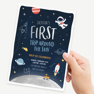 May include: A blue and black space-themed party invitation with a rocket, astronaut, planets, and stars. The text reads "Jackson's First Trip Around The Sun" with the date and time of the party. RSVP information is included at the bottom.