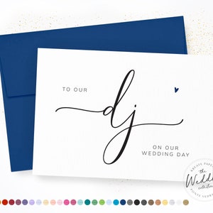 May include: A white wedding card with a navy blue envelope. The card reads "TO OUR DJ ON OUR WEDDING DAY" in elegant black script. A small blue heart is above the text. The card is from "The Wedding Collection".
