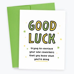 May include: A white greeting card with the words "GOOD LUCK" in green and yellow, with the text "trying to convince your new coworkers that you know what you're doing." A green envelope is behind the card.