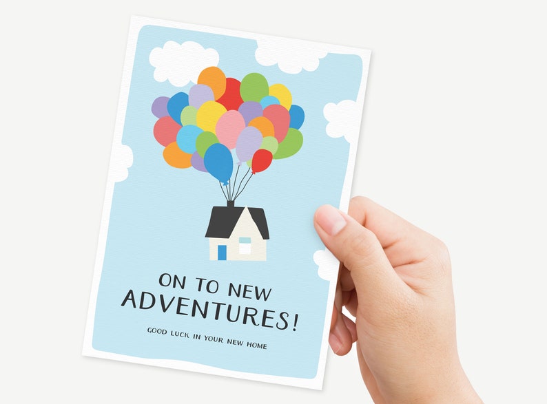 Puede incluir: Una tarjeta azul claro con una ilustraci&oacute;n de dibujos animados de una casa flotando en el aire con globos de colores. El texto en la tarjeta dice "On to new adventures! Good luck in your new home."