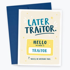 May include: Greeting card with a navy blue envelope. The card has the words "LATER TRAITOR" in teal and navy blue. Below is a yellow name tag that says "HELLO MY NAME IS TRAITOR". The card has a light beige background with yellow stars.