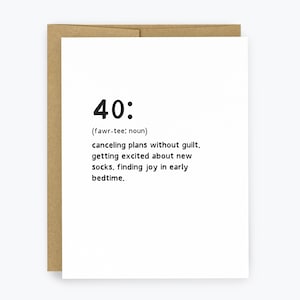 May include: A white greeting card with the number "40:" and a definition printed in black. The definition includes "canceling plans without guilt" and "finding joy in early bedtime." The card is inside a brown envelope.