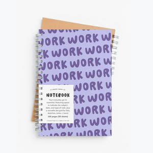 May include: A spiral-bound notebook with a lavender cover repeating the word "WORK" in a playful font. The notebook includes a small white label with the word "NOTEBOOK" and details about the pages.