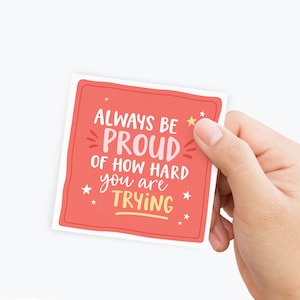May include: A red sticker with white border and yellow stars. The text on the sticker reads "Always be proud of how hard you are trying."