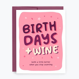 May include: A greeting card with a pink background and the words "BIRTHDAYS + WINE" in dark purple and white. The card also includes the text "both a little better when you stop counting" in a smaller font.