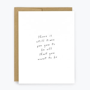 May include: A white greeting card with the text "there is still time for you to be all that you want to be" in black handwritten font. The card is inside a brown envelope.