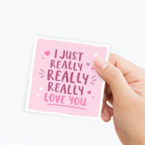 May include: Pink card with the text "I just really really really love you" in pink lettering with small pink hearts scattered around the text.