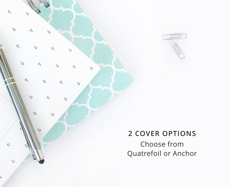 K&ouml;nnte beinhalten: Ein wei&szlig;es Notizbuch mit einem hellblauen, gemusterten Einband und einem silbernen Stift. Der Einband hat ein sich wiederholendes Kleeblatt-Muster. Der Text "2 COVER OPTIONS Choose from Quatrefoil or Anchor" ist auf wei&szlig;em Hintergrund sichtbar.