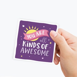 May include: Purple card with a pink banner that says "You are all kinds of awesome". The banner is wrapped around a yellow sun with rays. There are small white hearts and yellow stars scattered around the card.