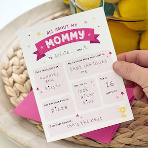 May include: A white paper questionnaire titled All About My Mommy with pink accents and yellow stars. The form includes handwritten fields filled out by Olivia, age 6, with answers about her mother, including her favorite food, pizza, and job.
