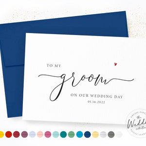 May include: A white card with a blue envelope. The card has the text "TO MY groom ON OUR WEDDING DAY 01.16.2022" and a small red heart.