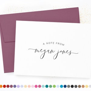 May include: A white card with a mauve envelope. The card has the text "A note from Megan Jones" in black script.