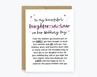 May include: A white greeting card with a brown envelope featuring black text that reads To my beautiful Daughter-in-law on her Wedding Day, followed by a message about family, joy, and love, accented with small pink and purple heart illustrations.