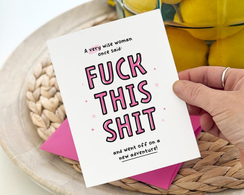 May include: A white greeting card with black and pink text that reads: A very wise woman once said: FUCK THIS SHIT and went off on a new adventure! The card features small pink stars scattered around the text and is paired with a bright pink envelope.